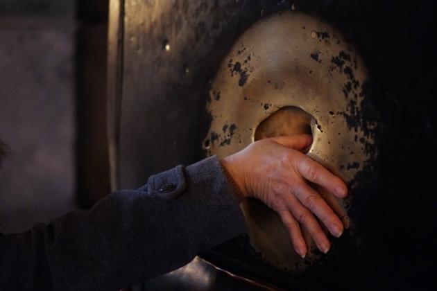 FILE - In this Monday, Dec. 21, 2015 file photo, a visitor from Greece touches the damp stone of a pillar named 'Weeping Pillar', where tradition says Emperor Justinian rested his aching head and was instantly cured, inside the Byzantine-era Hagia Sophia, in the historic Sultanahmet district of Istanbul. (AP)