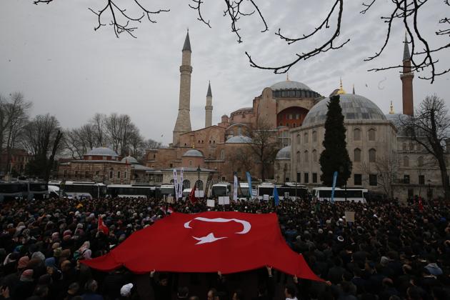 FILE - In this Saturday, March 16, 2019 file photo, backdropped by Hagia Sophia, the Byzantine-era cathedral that was turned into a mosque and now serves as a museum, demonstrators protest holding a Turkish flag. (AP)