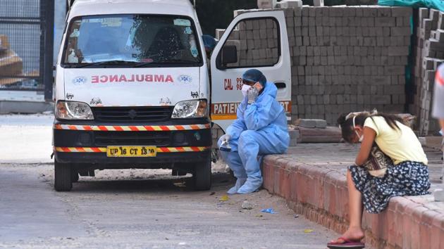 A medical professional in PPE overalls talks on the phone while waiting to transport people outside the Covid-19 ward at Lok Nayak Jai Prakash Hospital on July 1. Delhi CM Arvind Kejriwal in his media briefing on the same day said, “There was a day when nearly 125 deaths were recorded. Today, the daily Covid deaths are hovering around 60-65. We have to reduce this further,” (Raj K Raj / HT Photo) 