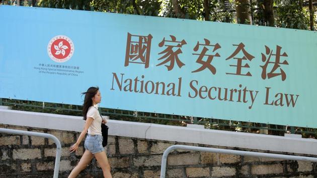 A woman walks past a promotional banner of the national security law for Hong Kong. (AP) A woman walks past a promotional banner of the national security law for Hong Kong. (AP)