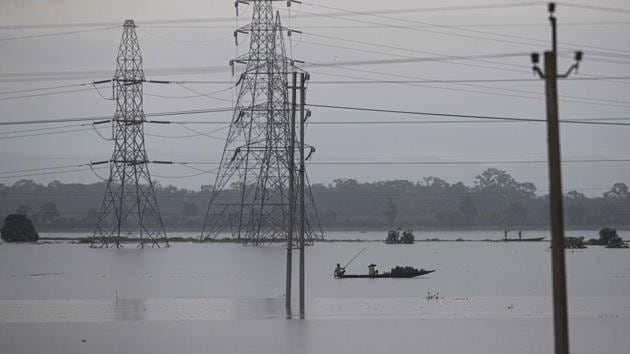 Villagers row country boats through floodwaters in Morigaon district of Assam. (AP) Villagers row country boats through floodwaters in Morigaon district of Assam. (AP)