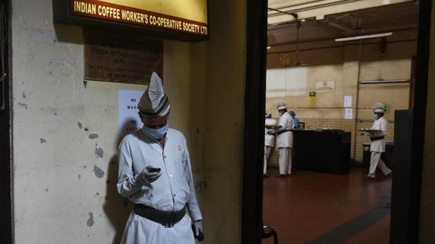 A server catches a break from the chaos of reopening day on July 2 at the Indian Coffee House in Kolkata. As the gates of the heritage eatery opened at 11 am, around 25 customers, most of them regulars at the eatery, walked in. (Samir Jana / HT Photo)