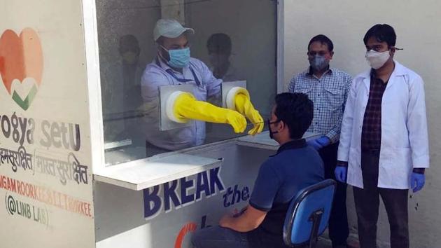 A doctor wearing protective gloves take swab of a patient for testing of coronavirus at portable COVID-19 screening booth, in IIT Roorkee.(ANI)