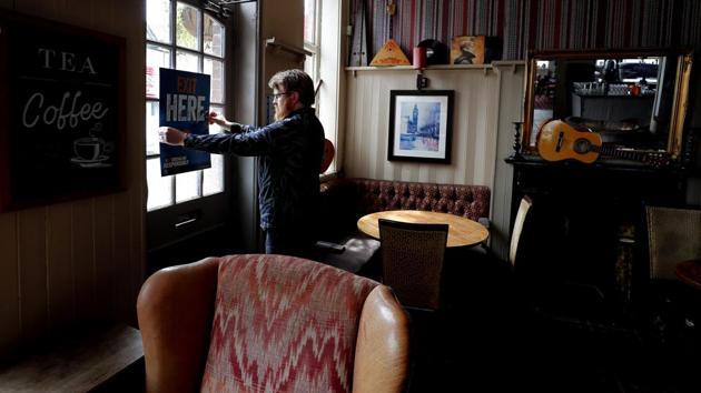 Owner Are Kjetil Kolltveit from Norway put signs in place instructing on social distancing at the Chandos Arms pub in London, Wednesday, July 1, 2020. (AP) Owner Are Kjetil Kolltveit from Norway put signs in place instructing on social distancing at the Chandos Arms pub in London, Wednesday, July 1, 2020. (AP)