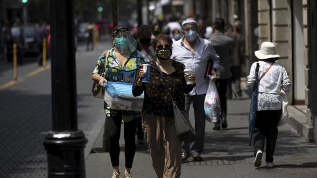 Pedestrians wearing protective face masks as a precaution against the spread of the coronavirus, in the historic center of Mexico City on July 2. According to a news report, experts have questioned the government’s tracking of the virus, as even the ministry has acknowledged actual cases are much higher. (Fernando Llano / AP) Pedestrians wearing protective face masks as a precaution against the spread of the coronavirus, in the historic center of Mexico City on July 2. According to a news report, experts have questioned the government’s tracking of the virus, as even the ministry has acknowledged actual cases are much higher. (Fernando Llano / AP)