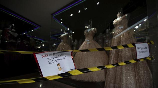 Held by caution tape, a sign with a message that reads in Spanish: “No entry allowed without a protective face mask,” is displayed at the entrance of clothing store in the historic centre of Mexico City on July 2. (Fernando Llano / AP) Held by caution tape, a sign with a message that reads in Spanish: “No entry allowed without a protective face mask,” is displayed at the entrance of clothing store in the historic centre of Mexico City on July 2. (Fernando Llano / AP)