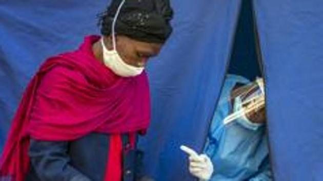 Heath officials check the listings of people who are to be tested for Covid-19 as well as HIV and Tuberculosis, in downtown Johannesburg. (AP) Heath officials check the listings of people who are to be tested for Covid-19 as well as HIV and Tuberculosis, in downtown Johannesburg. (AP)