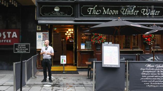 A member of the staff stands outside The Moon Under Water pub in London on July 4. According to a report by AP, the four nations of the UK — England, Scotland, Wales and Northern Ireland are easing the lockdown at different speeds. (Simon Dawson / Bloomberg)