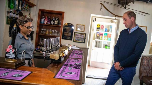 Britain's Prince William, Duke of Cambridge (R) chooses a drink at the bar of The Rose and Crown pub in Snettisham on July 3. Restaurants, hotels, cinemas and hairdressers in England reopened their doors for the first time yesterday after three months of lockdown due to Covid-19. (Aaron Chown / AFP)