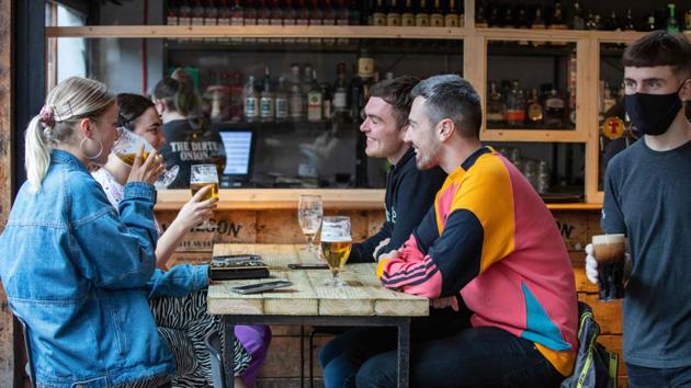 People enjoy a drink inside the Dirty Onion in Belfast on July 3. According to the latest government statistics, another 67 virus-related deaths were recorded on July 4 across the UK, the large majority in England, taking total fatalities to 44,198 which is by far the highest in Europe and third behind the United States and Brazil. (Paul Faith / AFP)