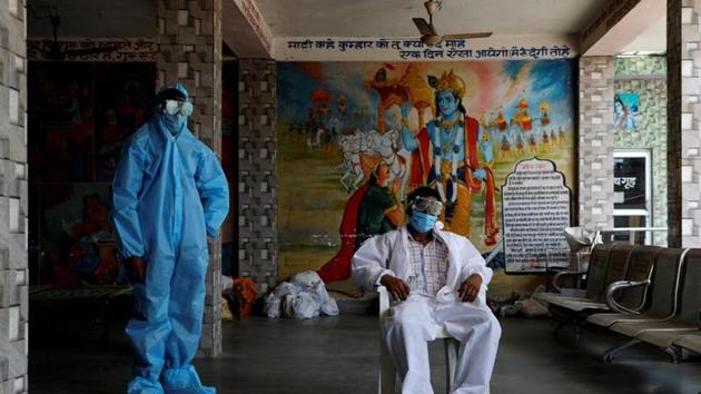 A priest and a labourer wear personal protective equipment (PPE) at a crematorium, amid the spread of the coronavirus disease in New Delhi, India, July 3, 2020.(REUTERS)