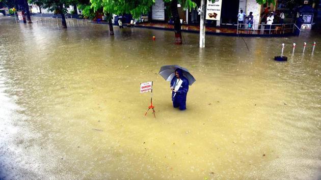 A municipal worker stands next to a sign warning passersby of an open manhole in Mumbai’s Parel on July 3. The IMD’s Colaba observatory recorded 169.0 mm rain during the last 24 hours ending 8.30am this morning. Santacruz observatory recorded 157.0 mm rainfall. These are the highest figures so far for this season. (Anshuman Poyrekar / HT Photo) A municipal worker stands next to a sign warning passersby of an open manhole in Mumbai’s Parel on July 3. The IMD’s Colaba observatory recorded 169.0 mm rain during the last 24 hours ending 8.30am this morning. Santacruz observatory recorded 157.0 mm rainfall. These are the highest figures so far for this season. (Anshuman Poyrekar / HT Photo)