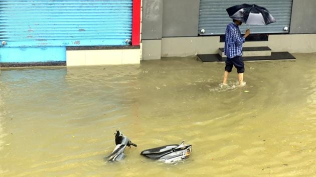 A man walks past a scooter ditched due to heavy water logging in Parel on July 3. Chaos wrought by the monsoon is an annual occurrence for the megacity in these months, with it low lying areas and other civic infrastructure such as the suburban railway network severely affected. (Anshuman Poyrekar / HT Photo) A man walks past a scooter ditched due to heavy water logging in Parel on July 3. Chaos wrought by the monsoon is an annual occurrence for the megacity in these months, with it low lying areas and other civic infrastructure such as the suburban railway network severely affected. (Anshuman Poyrekar / HT Photo)