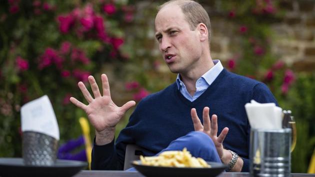 Britain's Prince William talks to the landlord and bar staff at The Rose and Crown pub in Snettisham, England, Friday July 3, 2020.  (AP) 