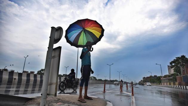 A man uses an umbrella to take shade from the rain, at NH-24, in New Delhi, India, on Thursday, June 25, 2020. (Raj K Raj/HT photo) A man uses an umbrella to take shade from the rain, at NH-24, in New Delhi, India, on Thursday, June 25, 2020. (Raj K Raj/HT photo)