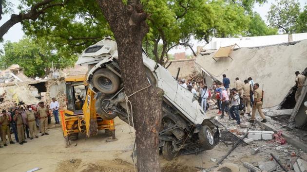A earthmover vehicle is used to remove mangled remains of a car during the demolition of the residence of criminal Vikay Dubey, after an encounter in Bikaru village where 8 police personnel lost their lives, in Kanpur (PTI) A earthmover vehicle is used to remove mangled remains of a car during the demolition of the residence of criminal Vikay Dubey, after an encounter in Bikaru village where 8 police personnel lost their lives, in Kanpur (PTI)