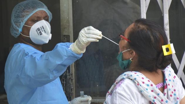 A health care worker takes a swab sample for Covid-19 rapid testing at the MMG district hospital in Ghaziabad, on Saturday.(Sakib Ali/HT Photo)
