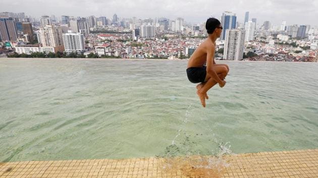A boy jumps into the water at the gold-plated infinity pool of the newly inaugurated Dolce Hanoi Golden Lake luxury hotel, after the government eased a nationwide lockdown following the global outbreak of the coronavirus disease (COVID-19), in Hanoi, Vietnam. (REUTERS/Kham)