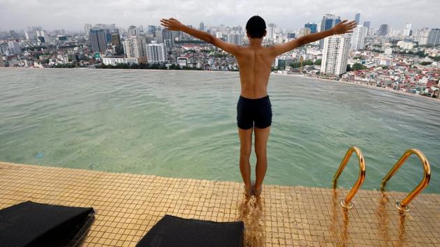 A boy jumps into the water at the gold-plated infinity pool of the newly inaugurated Dolce Hanoi Golden Lake luxury hotel, after the government eased a nationwide lockdown following the global outbreak of the coronavirus disease (COVID-19), in Hanoi, Vietnam. (REUTERS/Kham)