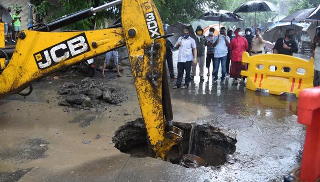 A part of Kharton Road caved in amid heavy rainfall in Thane on Sunday.(Praful Gangurde/HT Photo)