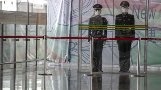 FILE - In this March 12, 2020, file photo, Chinese paramilitary policemen stand on duty behind a barrier at the Capital International Airport terminal 3 in Beijing. (AP) FILE - In this March 12, 2020, file photo, Chinese paramilitary policemen stand on duty behind a barrier at the Capital International Airport terminal 3 in Beijing. (AP)