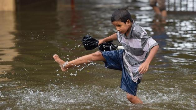 A boy wades through a waterlogged street during monsoon rain, at Sion in Mumbai. Heavy rains continued to lash Mumbai, Thane and other parts of Konkan Maharashtra for the third consecutive day on Sunday. (PTI)