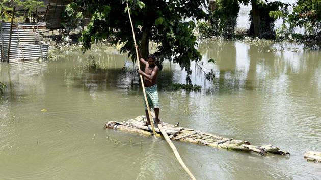 A man crosses a flooded area on a make-shift raft at Mayong near Morigaon district, in Guwahati on Saturday. (ANI Photo) A man crosses a flooded area on a make-shift raft at Mayong near Morigaon district, in Guwahati on Saturday. (ANI Photo)