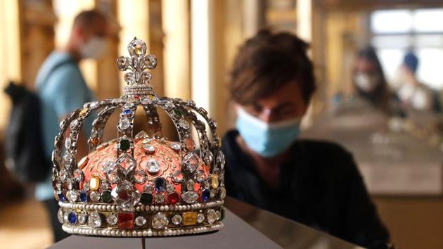 A visitor wearing a face mask stands in front of the jewel studded Crown of Louis XV housed in the Apollo gallery at the Louvre Museum on July 6. (FRANCOIS GUILLOT / AFP) A visitor wearing a face mask stands in front of the jewel studded Crown of Louis XV housed in the Apollo gallery at the Louvre Museum on July 6. (FRANCOIS GUILLOT / AFP)