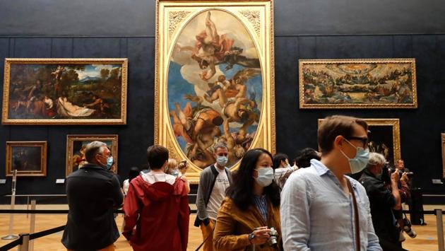 Visitors wearing face masks view artworks inside the Louvre Museum. According to a report by AFP, the museum hopes to attract more French visitors to fill the gap as it embarks on a campaign to shake off its elitist image before the Paris Olympics in four years’ time. (FRANCOIS GUILLOT / AFP) Visitors wearing face masks view artworks inside the Louvre Museum. According to a report by AFP, the museum hopes to attract more French visitors to fill the gap as it embarks on a campaign to shake off its elitist image before the Paris Olympics in four years’ time. (FRANCOIS GUILLOT / AFP)