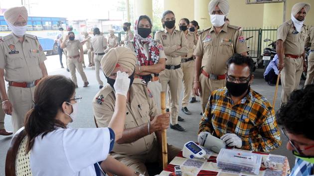 A paramedic using an infrared thermometer to record the temperature of a police officer on Covid-19 duty in Patiala (HT FILE PHOTO) A paramedic using an infrared thermometer to record the temperature of a police officer on Covid-19 duty in Patiala (HT FILE PHOTO)