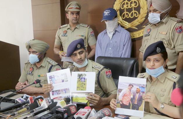 Mohali senior superintendent of police Kuldeep Singh Chahal (centre) addressing the media at his office on Monday. Ravinder Dandiwal , whose links to a fake T-20 cricket match is being probed, is standing behind him in a blue shirt .(Gurminder Singh/HT)