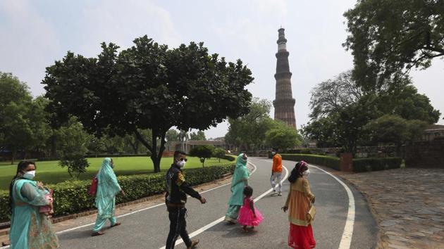 A family visits the Qutab Minar monument after monuments across India were reopened after almost four moths of lockdown to control the spread of coronavirus, in New Delhi. (AP) A family visits the Qutab Minar monument after monuments across India were reopened after almost four moths of lockdown to control the spread of coronavirus, in New Delhi. (AP)
