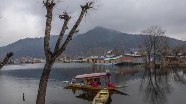 Tourists ride a Shikara, or a traditional boat, on the Dal Lake in Srinagar.(AP)