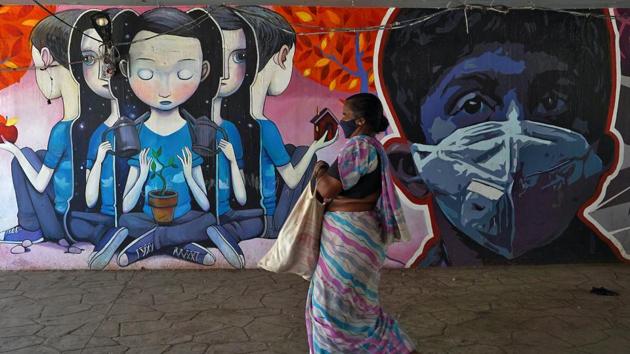 A woman wearing a protective mask walks past a graffiti during an extended nationwide lockdown to slow the spreading of coronavirus disease (Covid-19) in Mumbai. (Reuters) A woman wearing a protective mask walks past a graffiti during an extended nationwide lockdown to slow the spreading of coronavirus disease (Covid-19) in Mumbai. (Reuters)