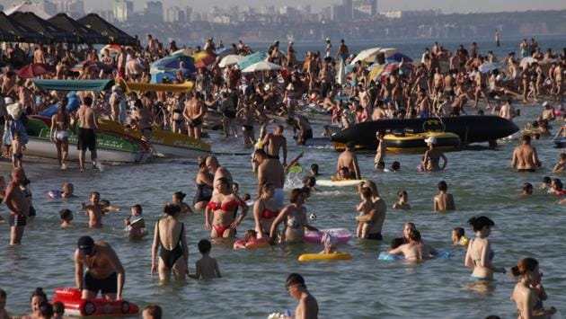 In the Ukrainian seaport of Odessa, tens of thousands of vacation-goers are out on beaches, paying little attention to safety measures despite levels of contagion still remaining high in both countries.The flow of visitors to seaside resorts comes at a time when both Russia and Ukraine are continuing to report high daily numbers of new cases. (AP) In the Ukrainian seaport of Odessa, tens of thousands of vacation-goers are out on beaches, paying little attention to safety measures despite levels of contagion still remaining high in both countries.The flow of visitors to seaside resorts comes at a time when both Russia and Ukraine are continuing to report high daily numbers of new cases. (AP)