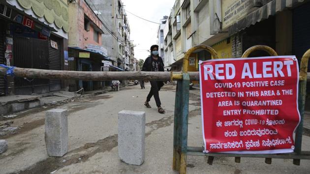 A man wearing a face mask walks past a public notice displayed on a makeshift barricade set up to restrict entry in a containment zone in Bengaluru. According to a HT report on July 7, coronavirus related incidents in Bengaluru are giving rise to a perception that after its initial success in curbing the Covid-19 spread, the Karnataka government has lost the plot in the battle against the pandemic, especially in Bengaluru. (Aijaz Rahi / AP) A man wearing a face mask walks past a public notice displayed on a makeshift barricade set up to restrict entry in a containment zone in Bengaluru. According to a HT report on July 7, coronavirus related incidents in Bengaluru are giving rise to a perception that after its initial success in curbing the Covid-19 spread, the Karnataka government has lost the plot in the battle against the pandemic, especially in Bengaluru. (Aijaz Rahi / AP)