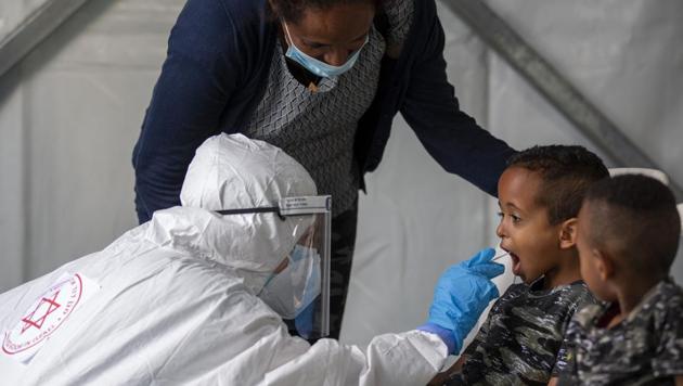 A child is tested by a healthcare worker for the coronavirus at testing center for migrants in Tel Aviv, Israel, Monday, July 6, 2020. Israel is reimposing a series of restrictions after seeing a surge of coronavirus infections in recent weeks. (Representational)(AP)