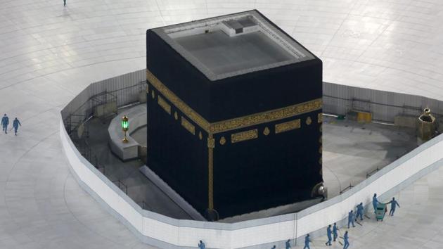Workers disinfect the ground around the Kaaba, the cubic building at the Grand Mosque, over fears of the new coronavirus, the Muslim holy city of Mecca, Saudi Arabia.(AP)