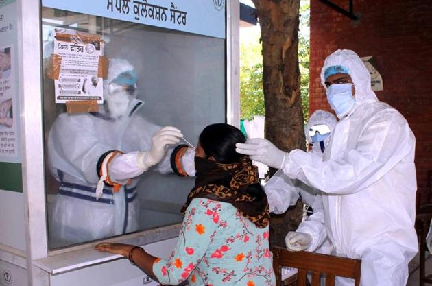 Health workers collecting a swab sample from a woman for Covid-19 testing at a government dispensary in Model Town, Patiala. (Bharat Bhushan/HT) Health workers collecting a swab sample from a woman for Covid-19 testing at a government dispensary in Model Town, Patiala. (Bharat Bhushan/HT)