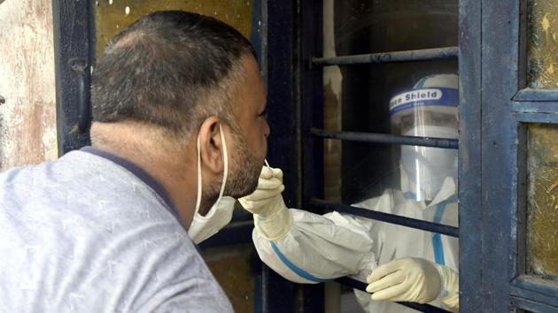 A medical worker collects a swab sample to conduct a rapid antigen test for coronavirus, at a testing centre in New Delhi’s Gandhi Nagar, on Tuesday.(Sonu Mehta/HT Photo)