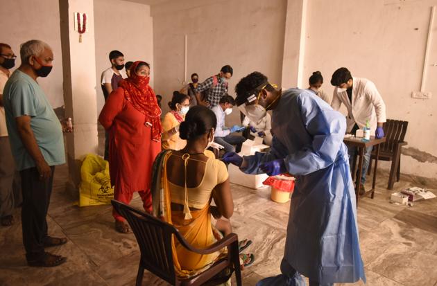 A health worker taking a swab sample for Covid-19 rapid antigen testing at an Anganwadi centre in Hari Nagar, Gurugram, on Wednesday.(PARVEEN KUMAR/HT)