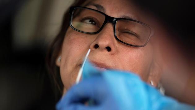 A woman has her nose swabbed as people wait in their vehicles in long lines for the coronavirus disease (COVID-19) testing in Houston, Texas, U.S., July 7, 2020.(REUTERS)