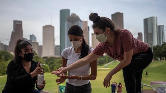 The Houston skyline is seen in the background as mask sporting residents share hand sanitizer after gathering in Eleanor Tinsley Park to make care packages for the local homeless community amid the global outbreak of the coronavirus disease in Houston, Texas, US. (REUTERS)