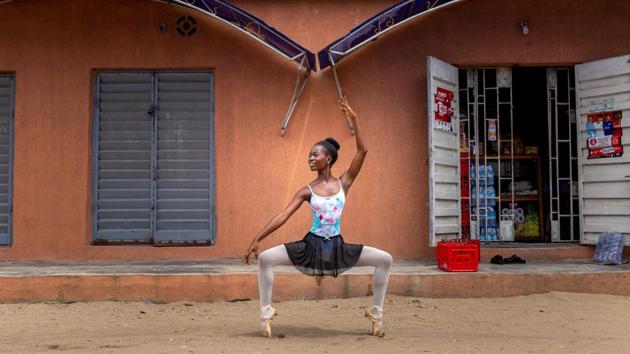 A student of the Leap of Dance Academy, Olamide Olawole, demonstrates an en pointe pose in the street on July 3. After years of engaging with the neighbourhood, when they practice their moves outside around the area, the students now draw admiring -- if sometimes still confused -- glances. (Benson Ibeabuchi / AFP)