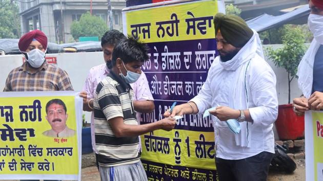 YAD district president Gurdeep Singh Gosha handing over fuel slips to commuters in a symbolic protest in Ludhiana on Thursday. (HT PHOTO) YAD district president Gurdeep Singh Gosha handing over fuel slips to commuters in a symbolic protest in Ludhiana on Thursday. (HT PHOTO)