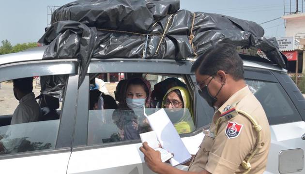 A Punjab police personnel checks the documents of Pakistani nationals as they return home, at Wagah Border post, near Amritsar,on Thursday, July 9, 2020.(Sameer Sehgal / HT Photo)