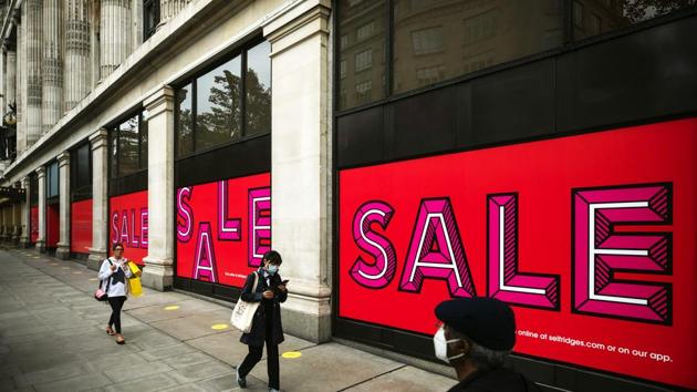 Pedestrians wearing protective face masks pass sales promotion signs in the windows of a Selfridges & Co. Ltd. department store on Oxford Street in London, U.K., on Thursday, July 9, 2020.(Bloomberg)