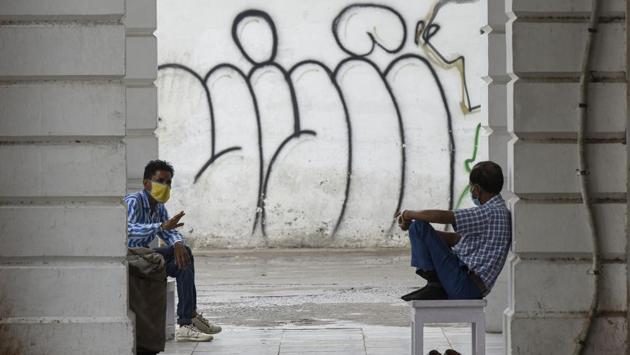 Men wearing face masks interact with each other on a rainy afternoon in New Delhi on July 7. The total number of active cases in the country stand at 2,69,789, according to the Union health ministry update on July 9. Over 4.7 lakh patients have been cured or discharged so far. (Biplov Bhuyan / HT Photo)