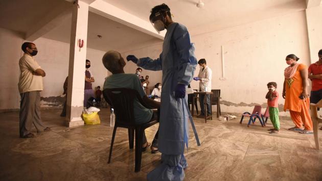 A health worker takes a sample for Covid-19 antigen testing in Gurugram on July 8. Testing figures for Covid-19 crossed the 1 crore mark earlier this week as a result of continuous expansion of testing network. ICMR data shows that 267,061 tests conducted on July 8 have taken the cumulative figure to 10,740,832. (Parveen Kumar / HT Photo)
