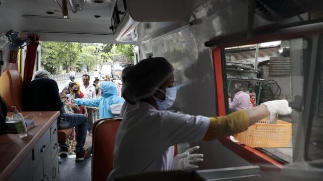Health workers in a mobile clinic conduct thermal checks and dispense medicine to residents during a survey in a slum in Pune on July 8. So far, 21,129 people have died due to the disease in the country, of which 487 deaths were recorded on July 8, health ministry data showed. (Rahul Raut / HT Photo)